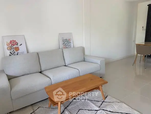 Modern living room with cozy sofa, wooden coffee table, and stylish decor in a bright, minimalist setting.