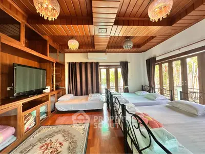 Spacious bedroom with wooden ceiling, multiple beds, and large windows for natural light.