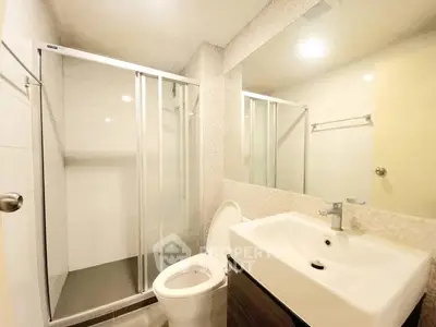 Modern bathroom with glass shower and sleek fixtures in a contemporary apartment.