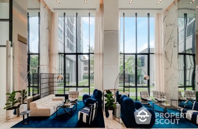 Luxurious double-height living room with floor-to-ceiling windows, elegant marble accents, and plush designer furniture creating an opulent space for entertaining.