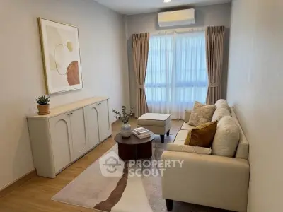 Cozy living room with modern decor, featuring a stylish sofa, elegant curtains, and a chic wall art piece.