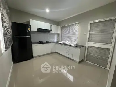 Modern kitchen with sleek cabinetry and black appliances in a spacious layout