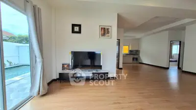 Spacious living room with pool view and modern kitchen in open layout home