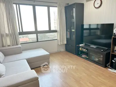 Bright living room with large windows and modern furniture, perfect for relaxation.