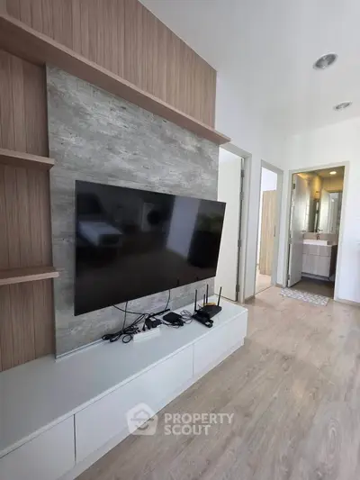 Modern living room with sleek TV setup and stylish decor in a contemporary apartment.