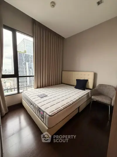 Modern bedroom with large window and city view in high-rise apartment