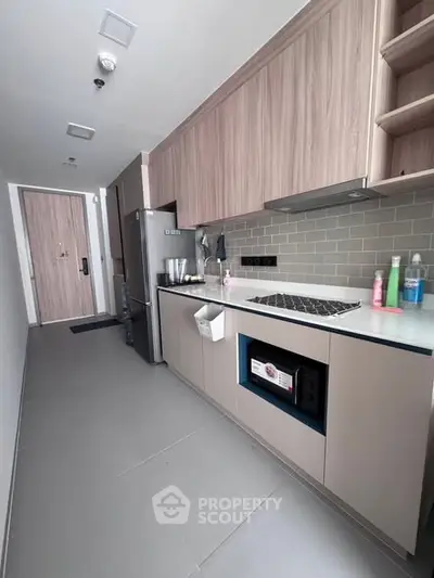 Modern kitchen with sleek cabinetry and built-in gas stove in a stylish apartment.