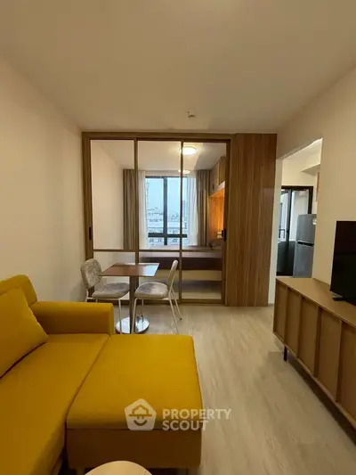 Modern living room with yellow sofa and wooden accents, featuring a cozy dining area and large window view.