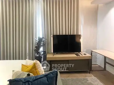 Modern living room with stylish decor and large TV, perfect for relaxation and entertainment.