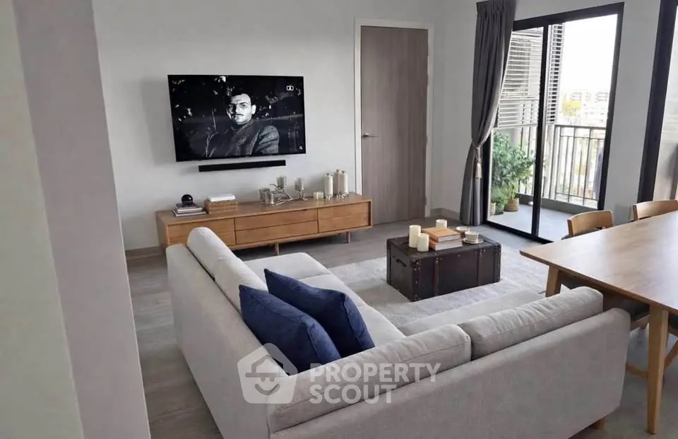 Modern living room with stylish furniture and balcony view, perfect for urban living.