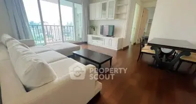 Spacious living room with white sofa and city view balcony in modern apartment