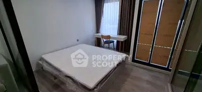 Modern bedroom with large window and desk, featuring minimalist design and natural light.