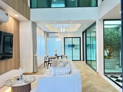 Luxurious modern living room with high ceilings and elegant decor, featuring large windows and stylish furniture.