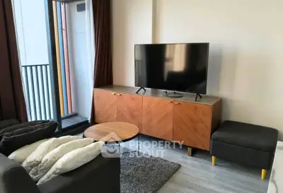 Modern living room with sleek TV stand and cozy seating area near balcony.
