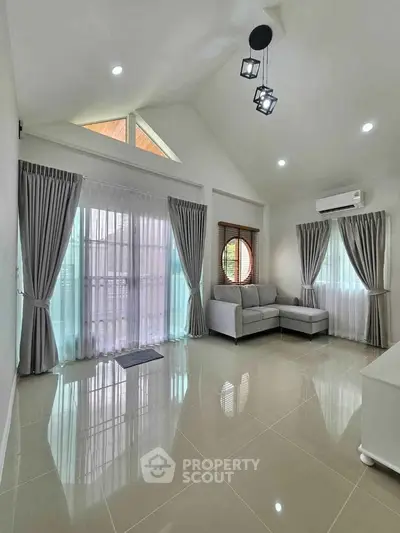 Spacious living room with modern decor and large windows for natural light.