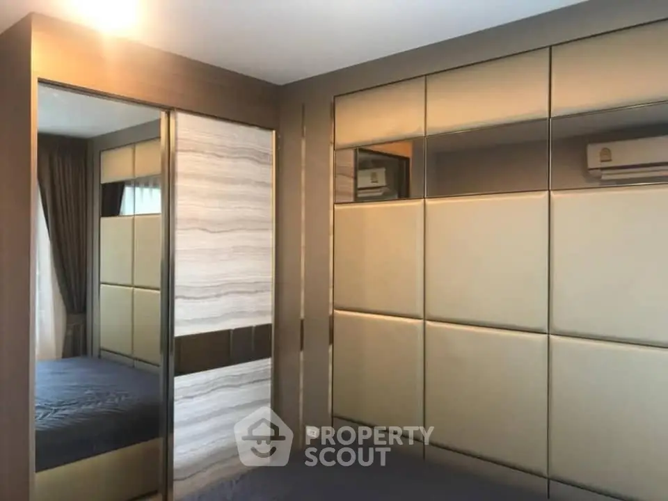 Modern bedroom with stylish paneling and mirrored wardrobe