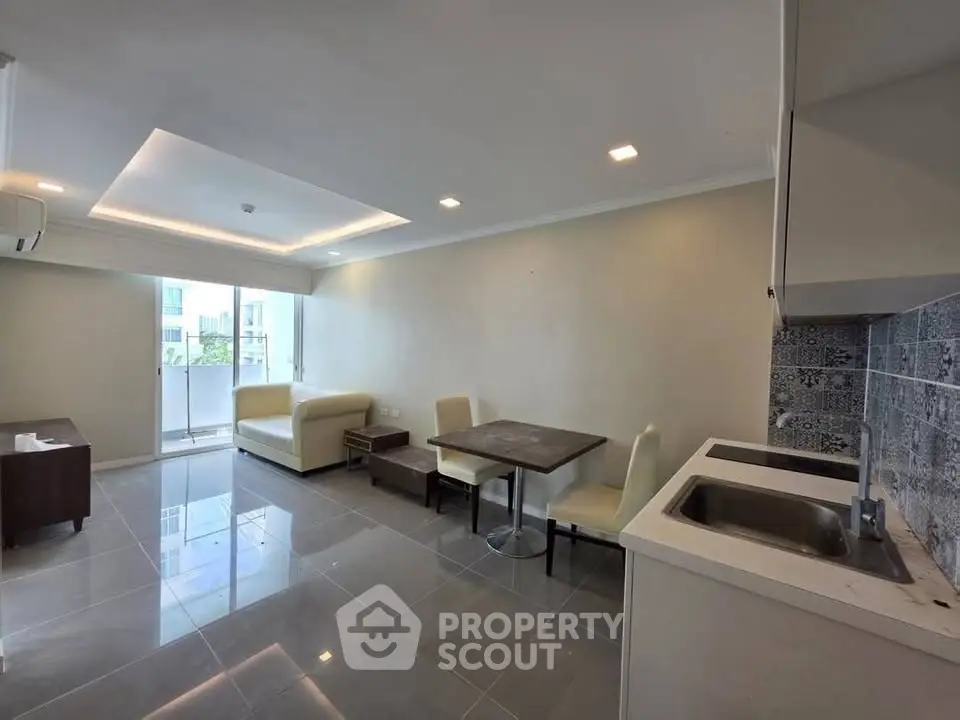 Modern open-plan living room with sleek kitchen and cozy dining area