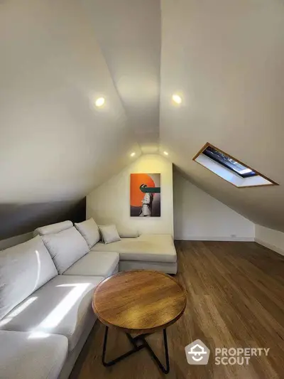 Stylish attic living room with modern decor and skylight