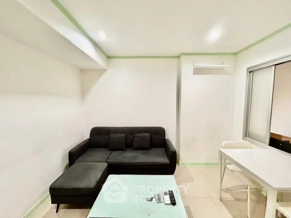 Modern living room with sleek black sofa and minimalist decor, perfect for urban living.
