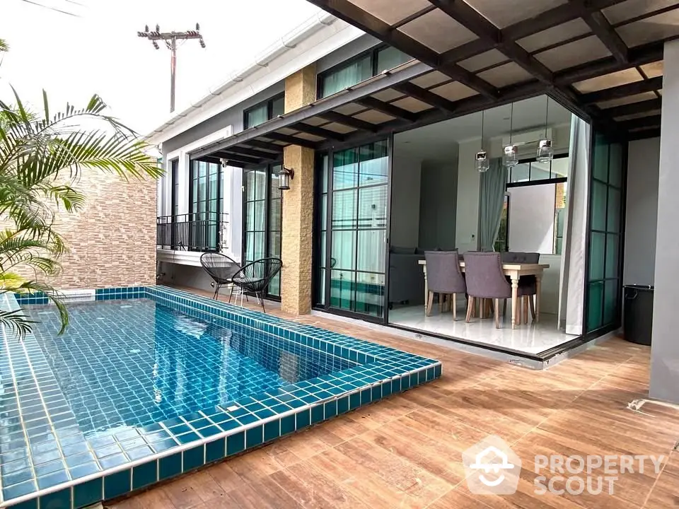 Modern home with private pool and stylish dining area, perfect for luxury living.