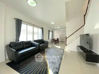 Spacious modern living room with sleek black sofas and stylish decor