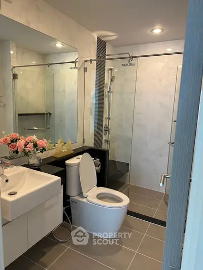 Modern bathroom with glass shower and elegant fixtures in a stylish real estate property.