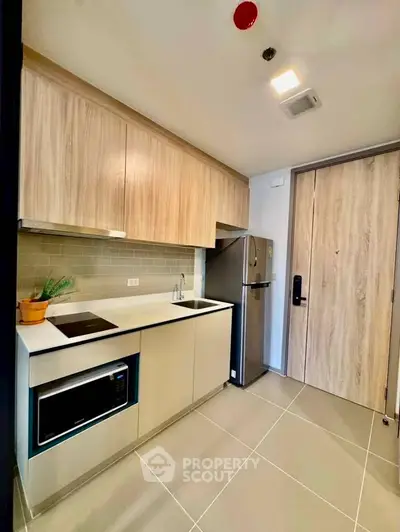 Modern kitchen with sleek cabinetry and stainless steel appliances in a stylish apartment.