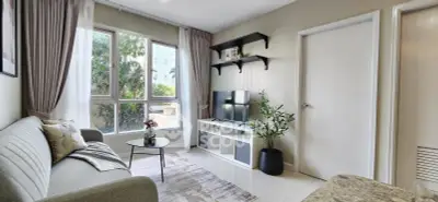 Modern living room with large window, stylish decor, and cozy seating area.
