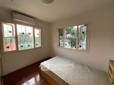 Cozy bedroom with natural light and air conditioning, perfect for relaxation.
