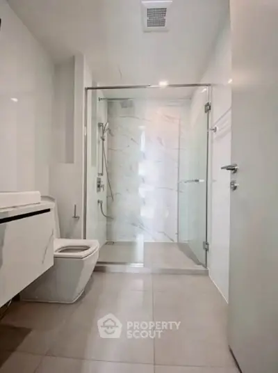 Modern bathroom with glass shower and sleek fixtures in a contemporary home.