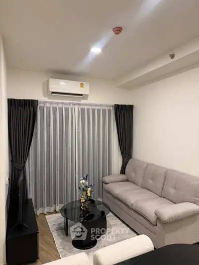 Modern living room with cozy sofa, sleek black coffee table, and elegant curtains in a stylish apartment.