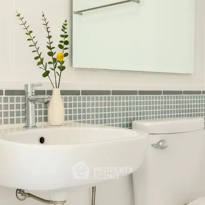 Modern bathroom with stylish sink and elegant tile backsplash.