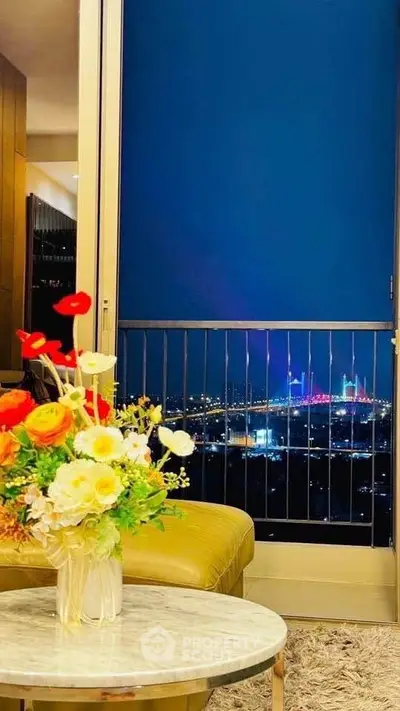 Luxurious living room with stunning city view and elegant floral arrangement.