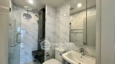 Modern bathroom with glass shower and marble tiles