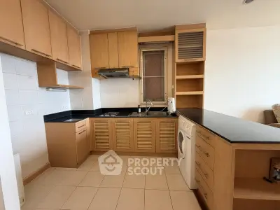 Spacious kitchen with modern wooden cabinetry and built-in appliances, perfect for culinary enthusiasts.