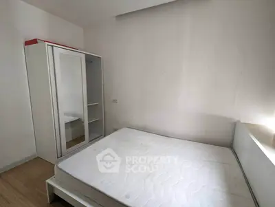 Minimalist bedroom with white wardrobe and bed frame, perfect for modern living.