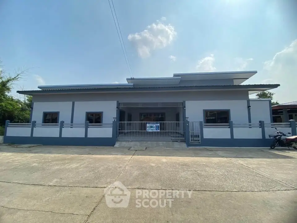 Modern single-story building with a sleek facade and spacious driveway, perfect for commercial or residential use.