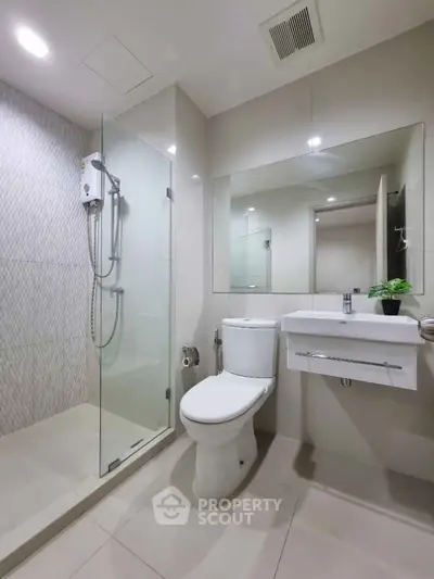 Modern bathroom with glass shower and sleek fixtures in a contemporary apartment.