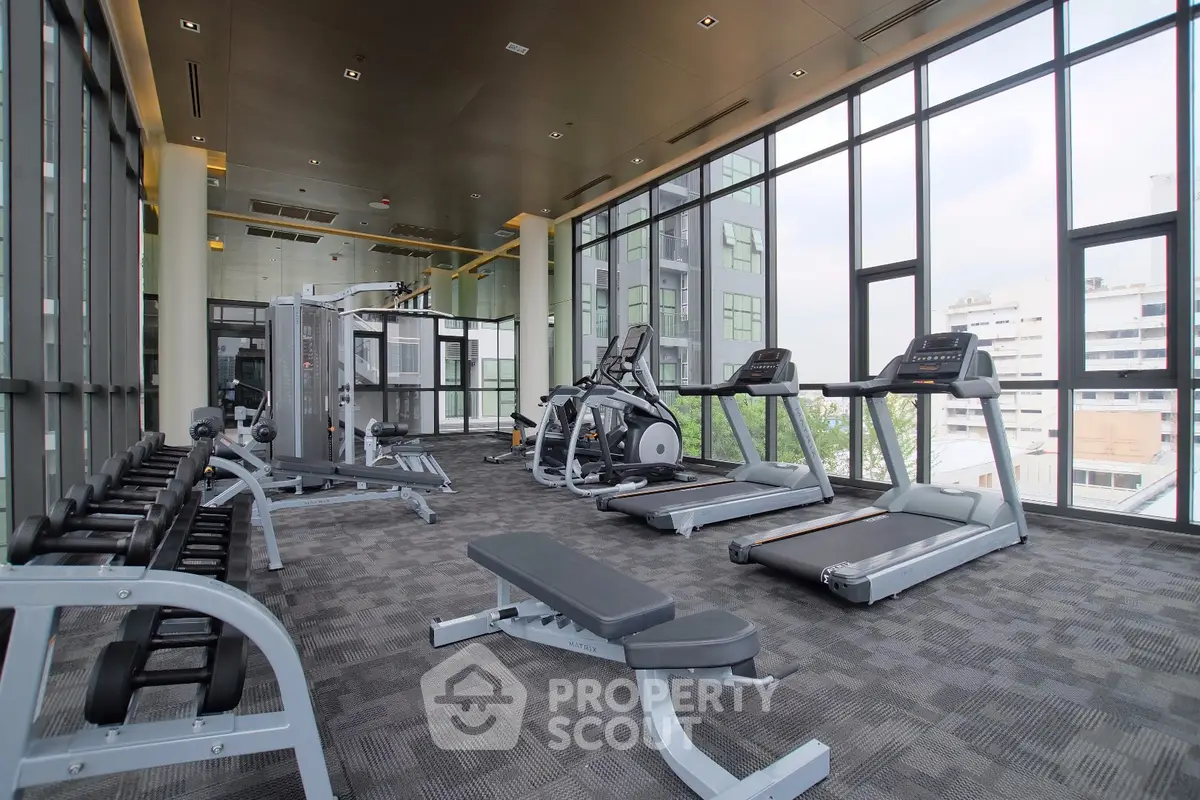 Spacious modern gym with city view in luxury apartment complex
