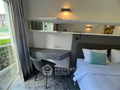 Modern bedroom with sleek design, featuring a cozy bed, stylish chair, and large window for natural light.