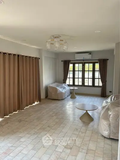 Spacious living room with large windows and modern furnishings in a bright home.