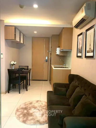 Cozy living room with modern kitchen and dining area in compact apartment.