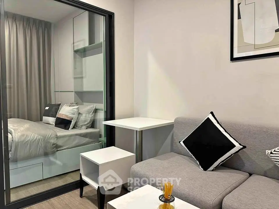 Modern studio apartment with glass partition, cozy living area, and stylish decor.