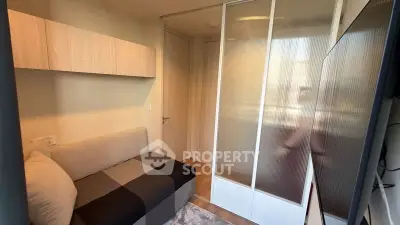 Cozy small bedroom with modern sliding door wardrobe and compact sofa bed.