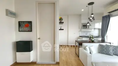 Modern open-layout living room and kitchen with stylish decor and natural light.