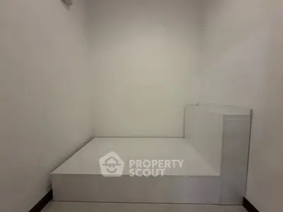 Minimalist white room with built-in platform bed and clean lines