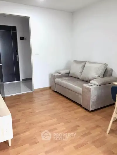 Modern living room with cozy sofa and wooden flooring in a stylish apartment.