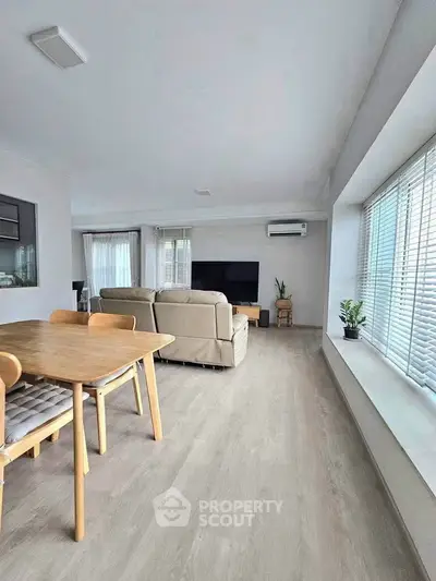 Spacious modern living room with large windows and stylish furniture, perfect for family gatherings.