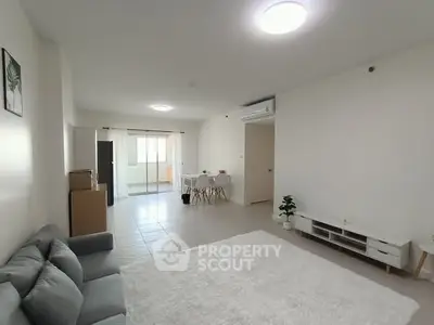 Spacious modern living room with cozy sofa and dining area, perfect for relaxation.