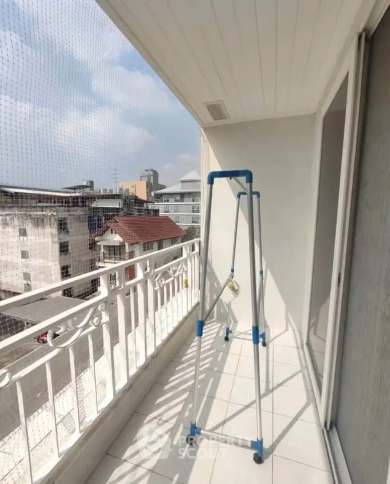Spacious balcony with city view and drying rack, perfect for urban living.